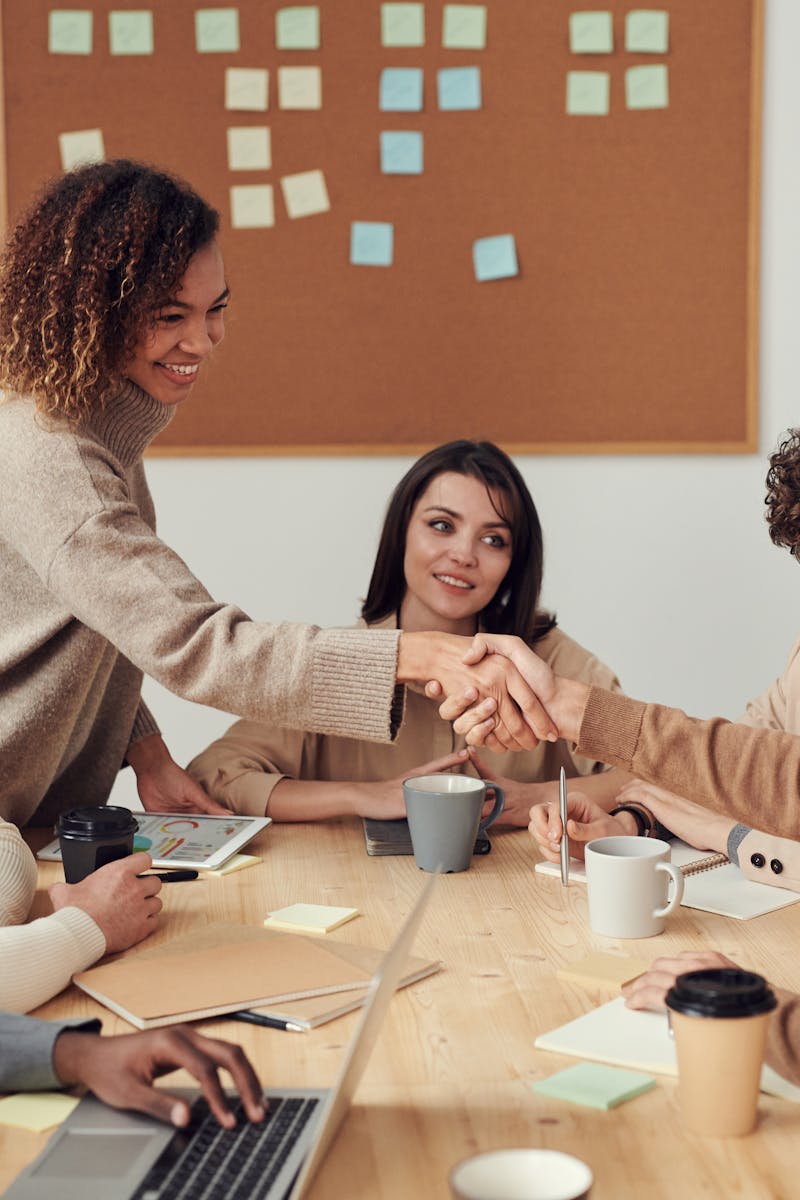 Diverse team collaborating in a meeting, showcasing teamwork and cooperation in a modern workplace.